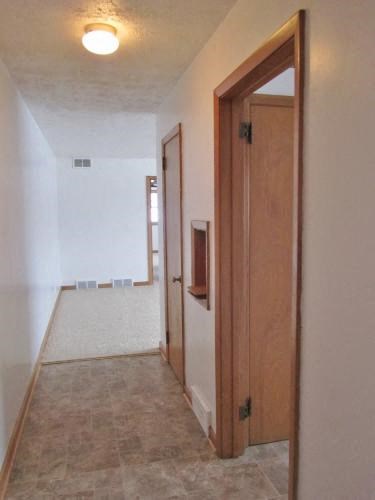 a hallway with an open door and a door to a bathroom