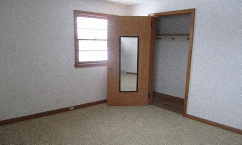 an empty room with a mirror and a door