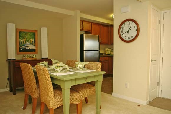 a dining room table with a clock on the wall