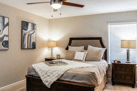 A bedroom with a bed, nightstand, and two lamps.
