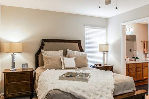 A bedroom with a large bed and a wooden dresser.