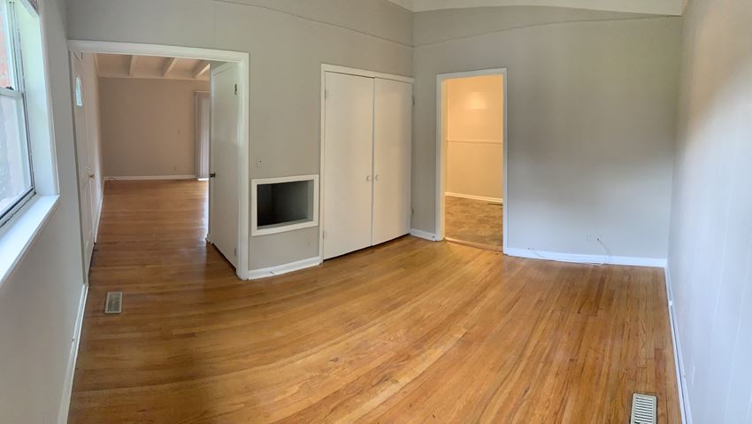 an empty living room with wood flooring and a fireplace