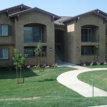 Exterior view of building and sidewalk l Villa Esperanza Apartments in Avenal CA