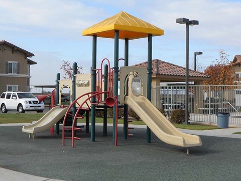 a playground with a yellow and red play set