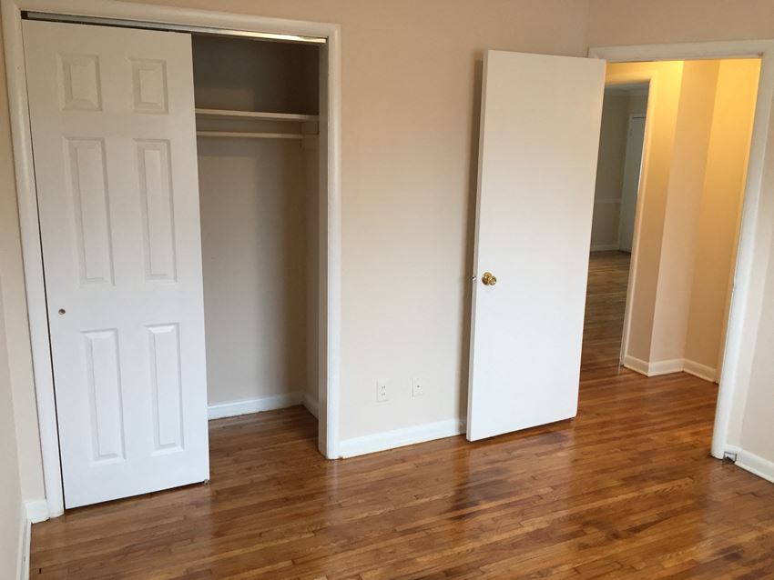 an empty room with two closets and a hard wood floor