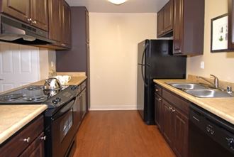 a kitchen with brown cabinets and black appliances