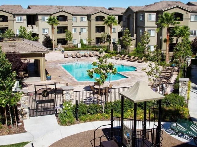 Pool with lounge chairs l The Villas at Villaggio Apartments in Modesto CA 