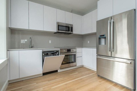 a kitchen with white cabinets and stainless steel appliances