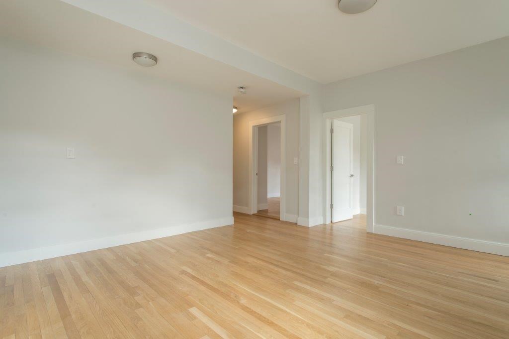 an empty living room with a hard wood floor