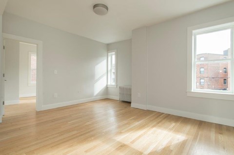 an empty living room with a hard wood floor
