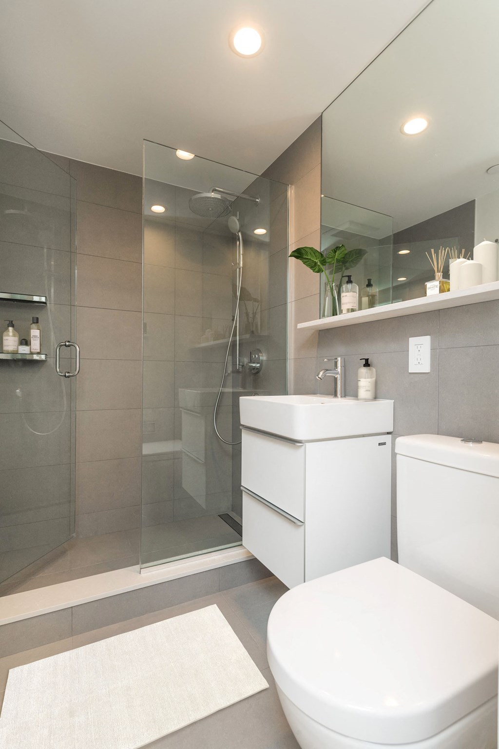 a white bathroom with a shower toilet and sink