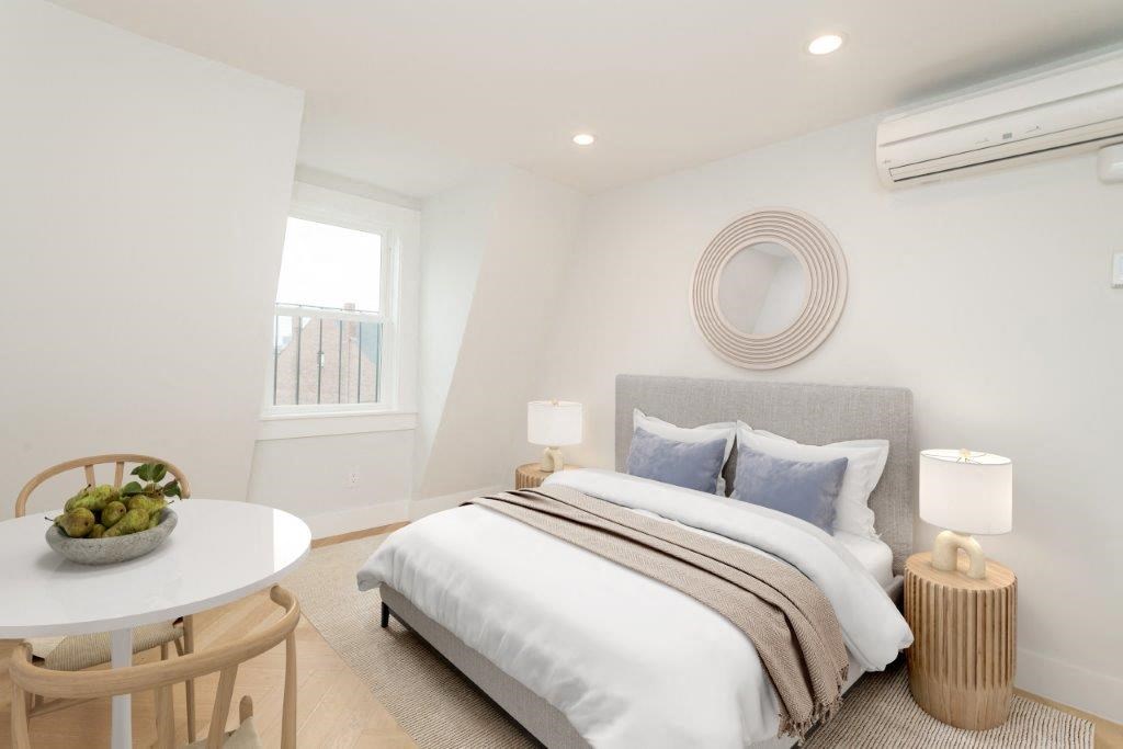 a bedroom with a bed and a table and a window