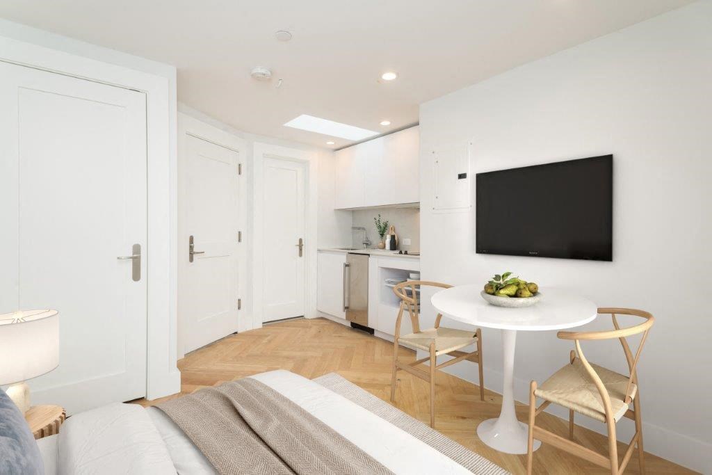 a small room with a bed and a table and a television