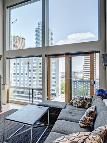 a living room with a large window and a couch and a table