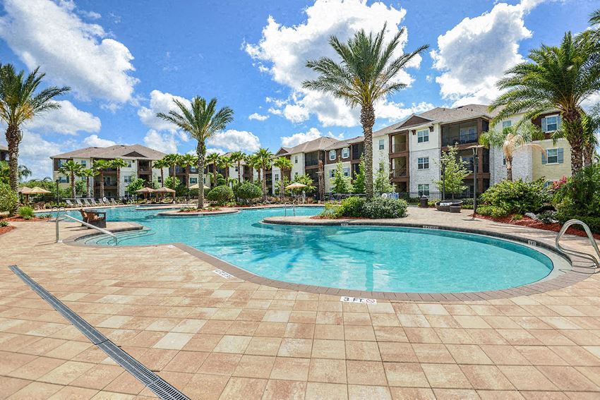 a large swimming pool in front of an apartment building