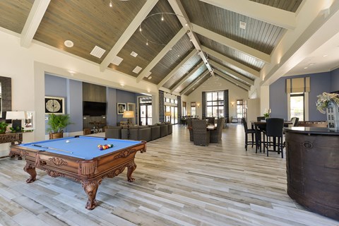 a large living room with a pool table in the middle