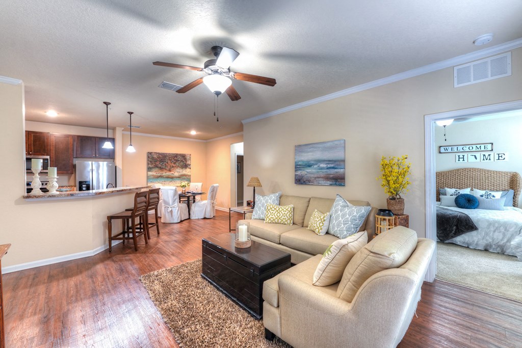 A living room with a beige couch, a coffee table, and a ceiling fan at Cabana Club Apartments, Florida 32256
