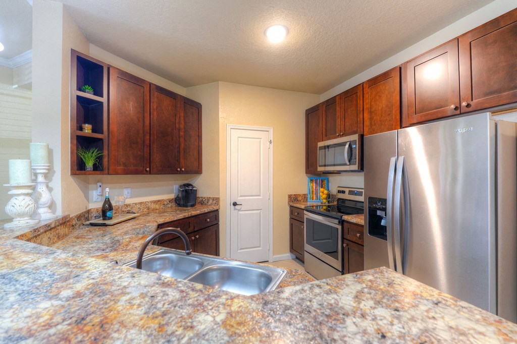 A kitchen with granite countertops and stainless steel appliances at Cabana Club Apartments, Jacksonville, FL, 32256