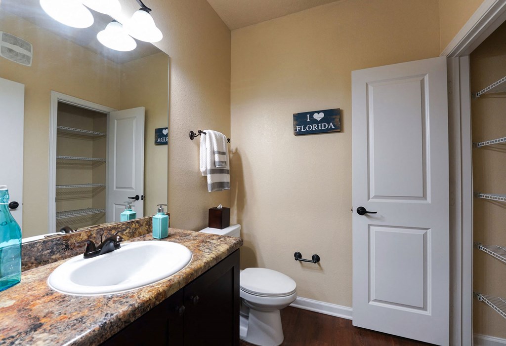 A bathroom with a sink, toilet and a sign that says I love Florida at Cabana Club Apartments, Florida