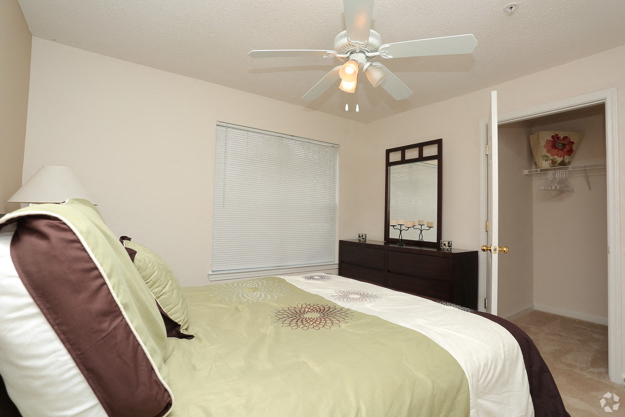 a bedroom with a large bed and a ceiling fan