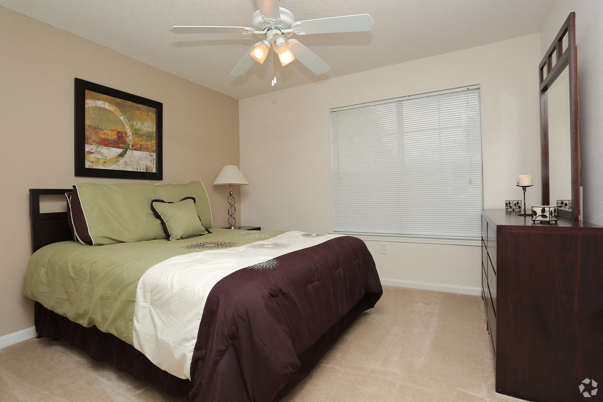 a bedroom with a bed and a ceiling fan