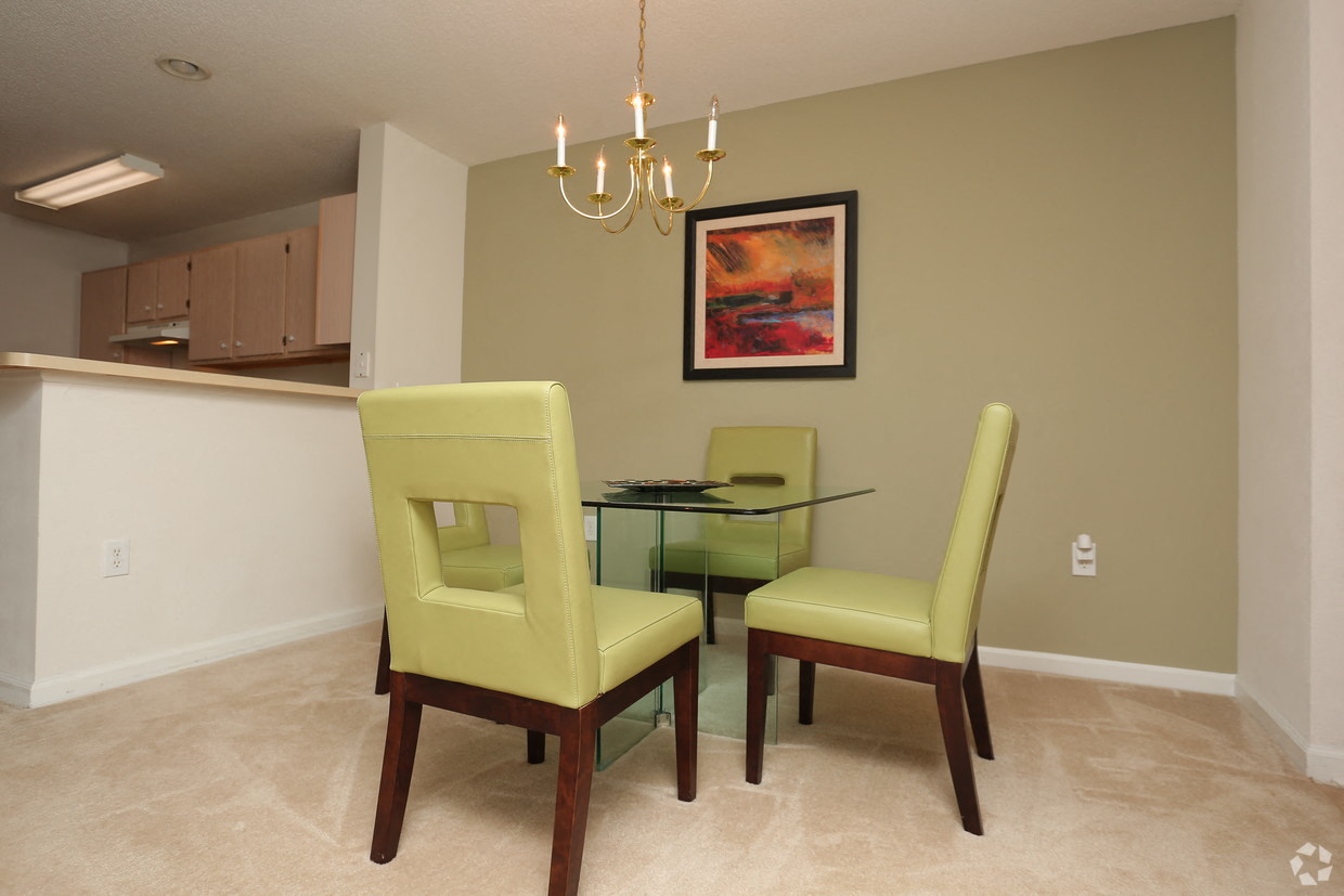 a dining room with yellow chairs and a glass table
