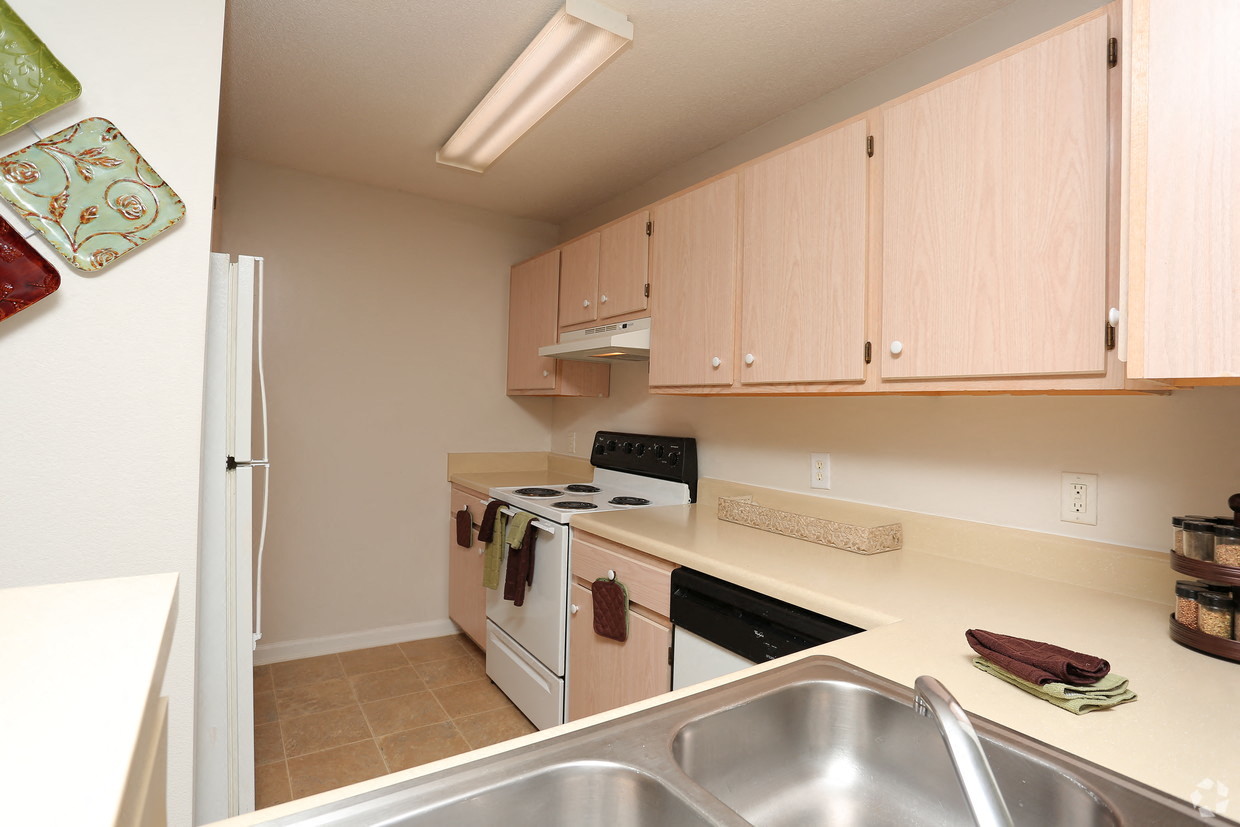 a kitchen with white appliances and wooden cabinets