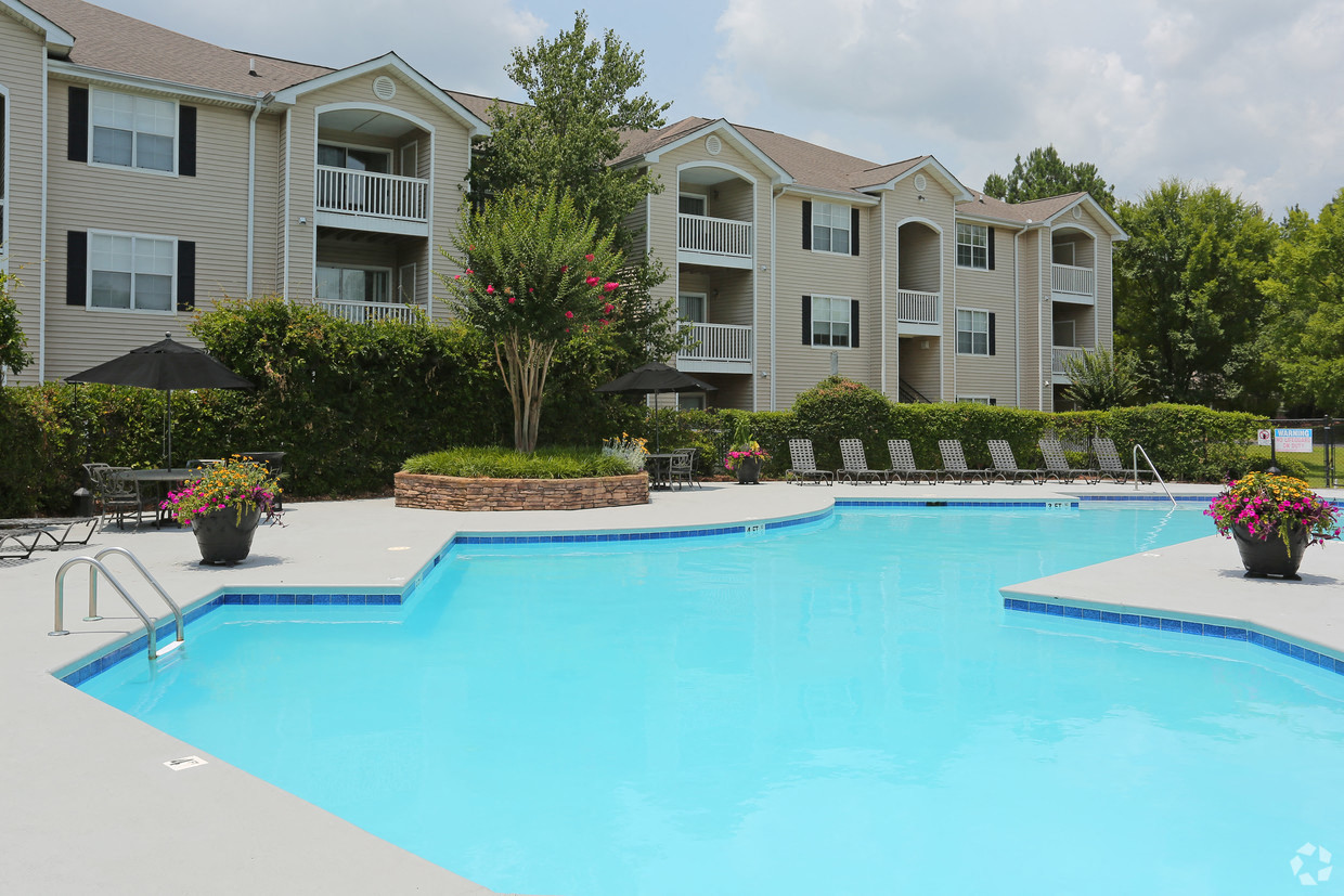 a large swimming pool with an apartment building in the background