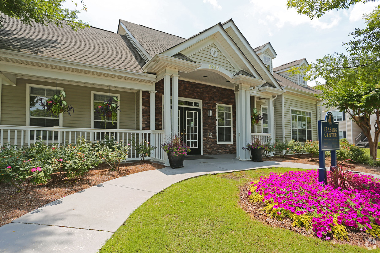 the front of a house with a walkway and flowers