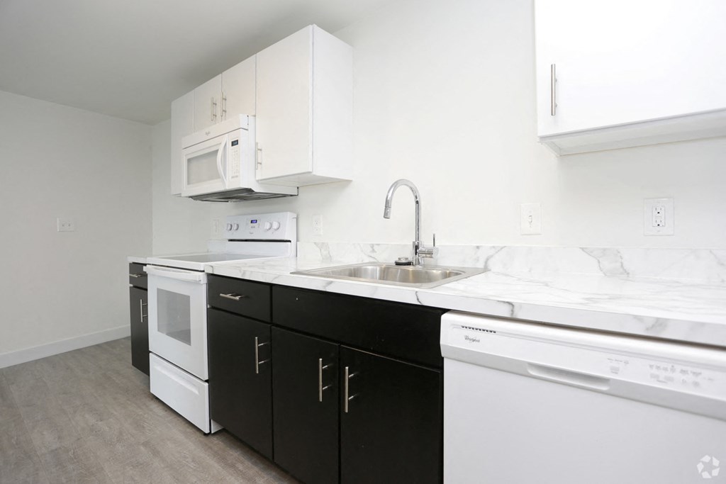 a kitchen with white appliances and white cabinets and a sink