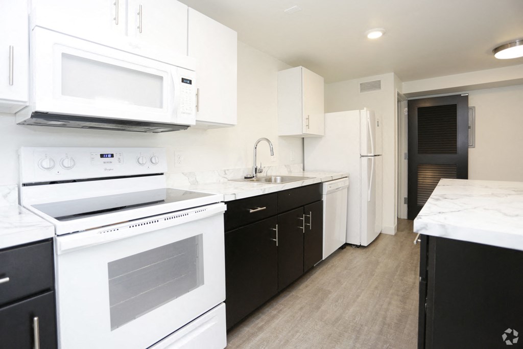 a kitchen with white appliances and black and white cabinets