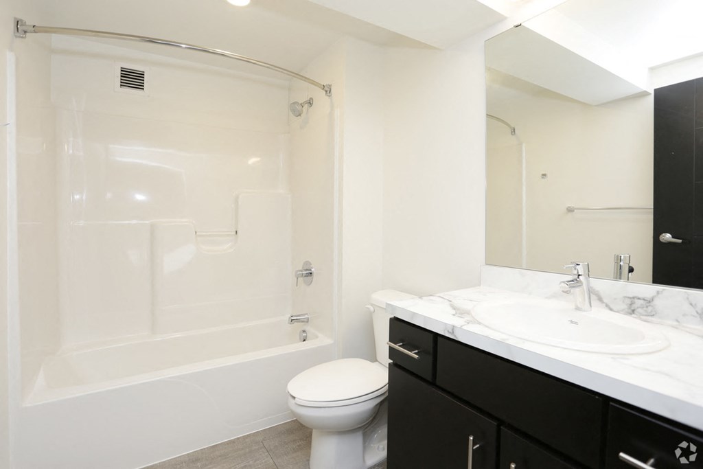 a bathroom with a shower and a sink and a toilet