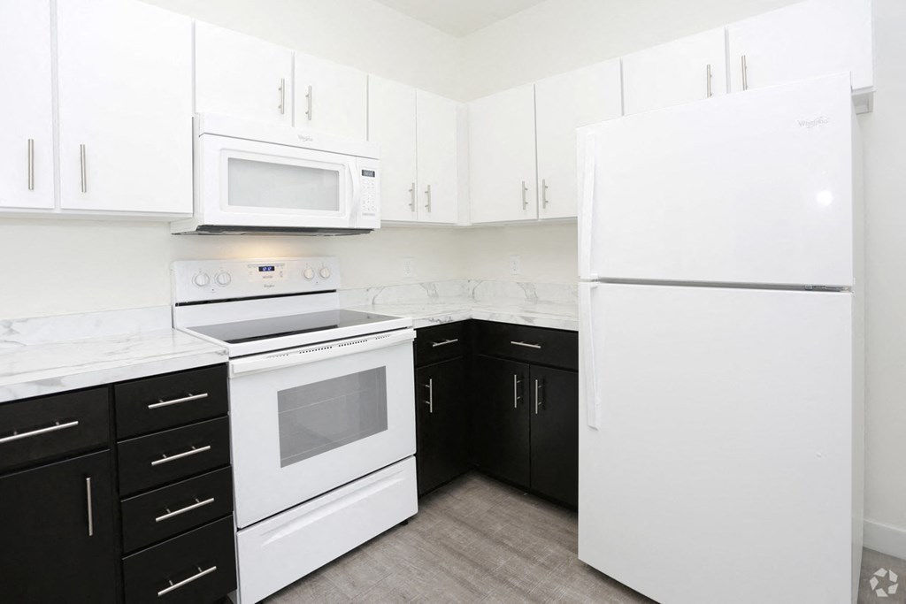 a kitchen with white appliances and black and white cabinets