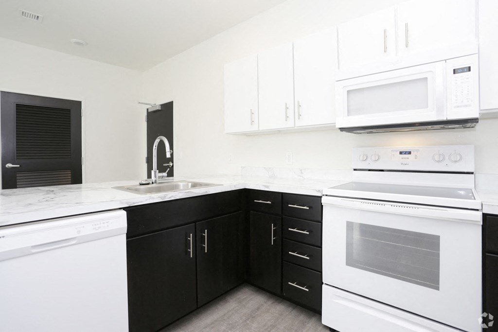 a kitchen with white appliances and black and white cabinets