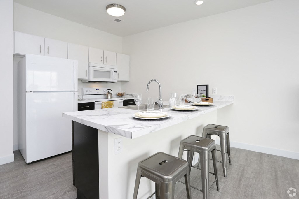 a kitchen with a marble counter top and three bar stools
