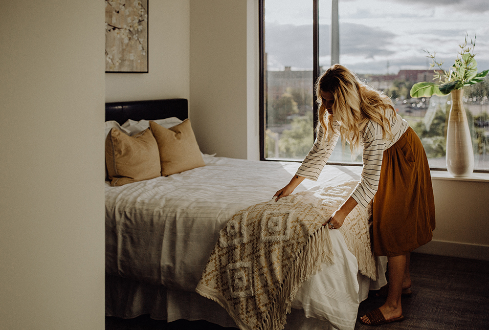 a woman standing on a bed in a bedroom