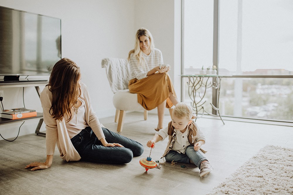 a mother playing with her two daughters in the living room