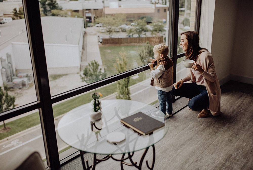 a woman and child looking out of a large glass window