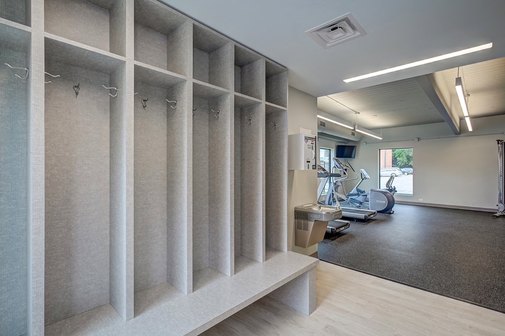 a large room with a gym with machines and a wood floor