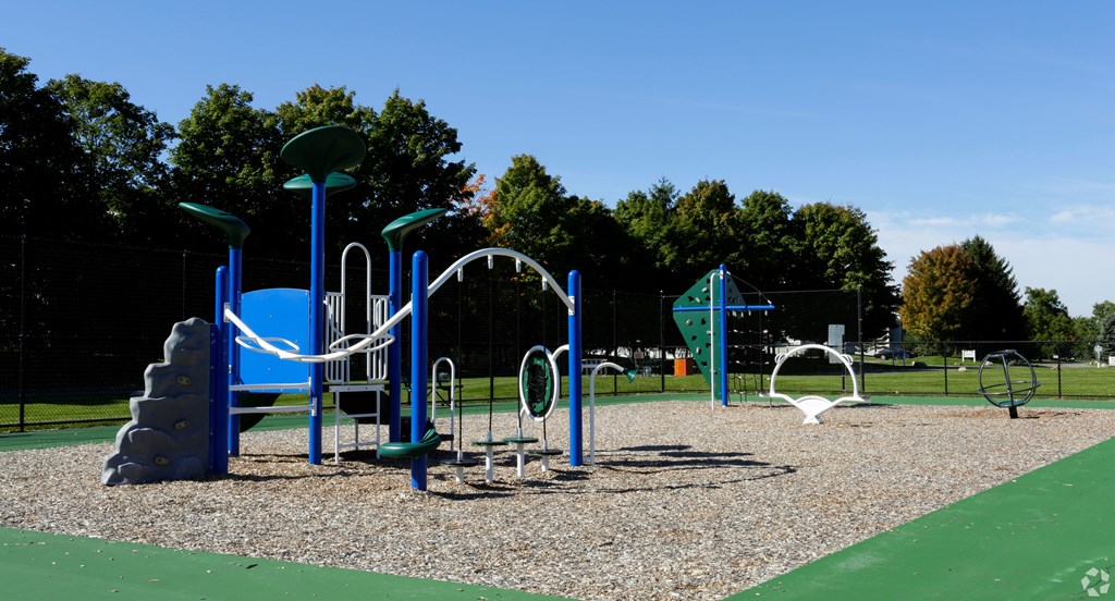 a playground with a swing set and slides at a park