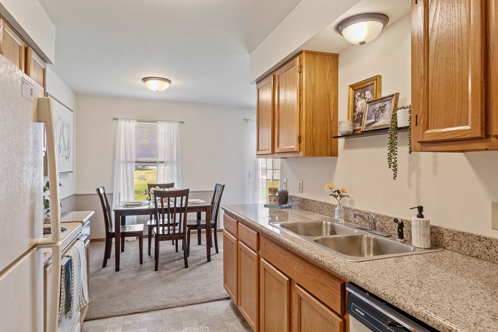 A kitchen with wooden cabinets and a table set for four.