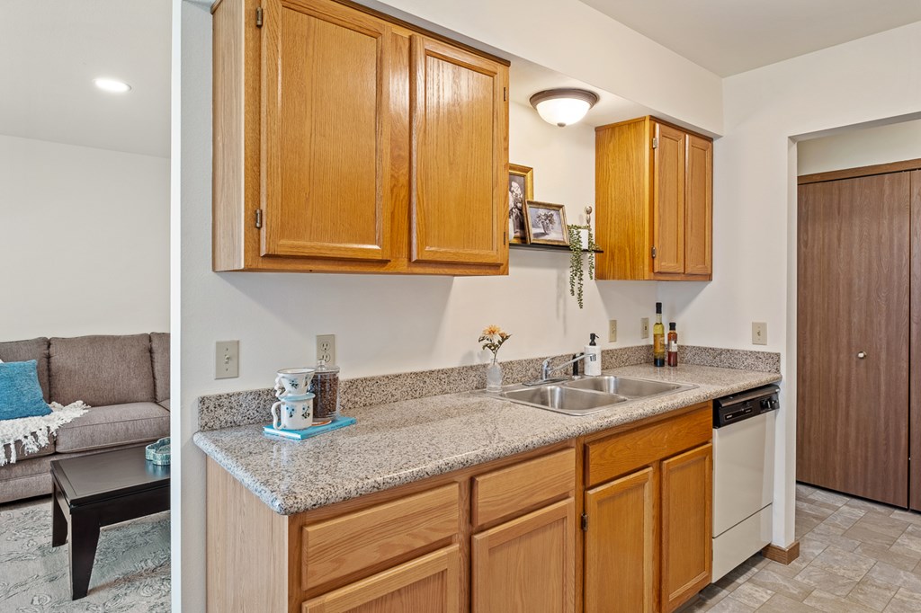 A kitchen with wooden cabinets and a granite countertop.