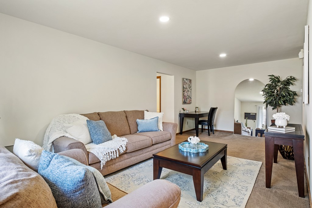 A living room with a brown couch and a coffee table.