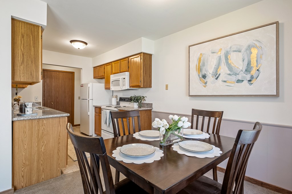 A dining room with a table set for four.