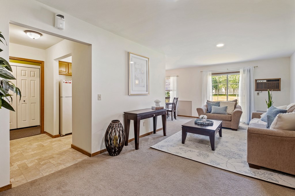 A living room with a brown couch, a coffee table, and a rug.
