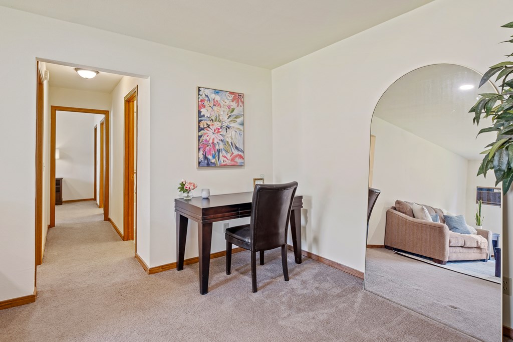 A room with a table and chairs and a painting on the wall.