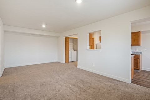 A spacious room with a carpeted floor and white walls.