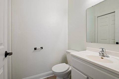 A white toilet sits next to a white sink in a bathroom.