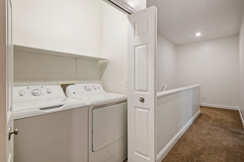 A small laundry room with a washer and dryer.