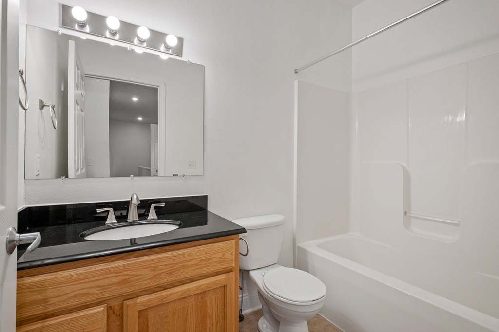 A bathroom with a toilet, sink, and bathtub.